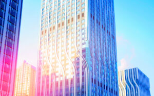 Tall glass skyscraper with white wavy vertical lines against a blue sky.