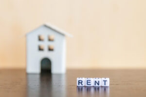 Miniature toy model house with inscription RENT letters word on wooden backdrop Eco Village abstract environmental background Real estate mortgage property insurance sweet home ecology rent concept - Texas Hotel and Lodging
