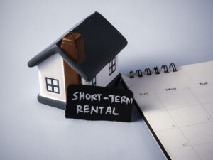 Miniature House and Desk Calendar with Short-Term Rental Text Concept for Temporary Housing Travel Accommodation and Property Income - Texas Hotel and Lodging